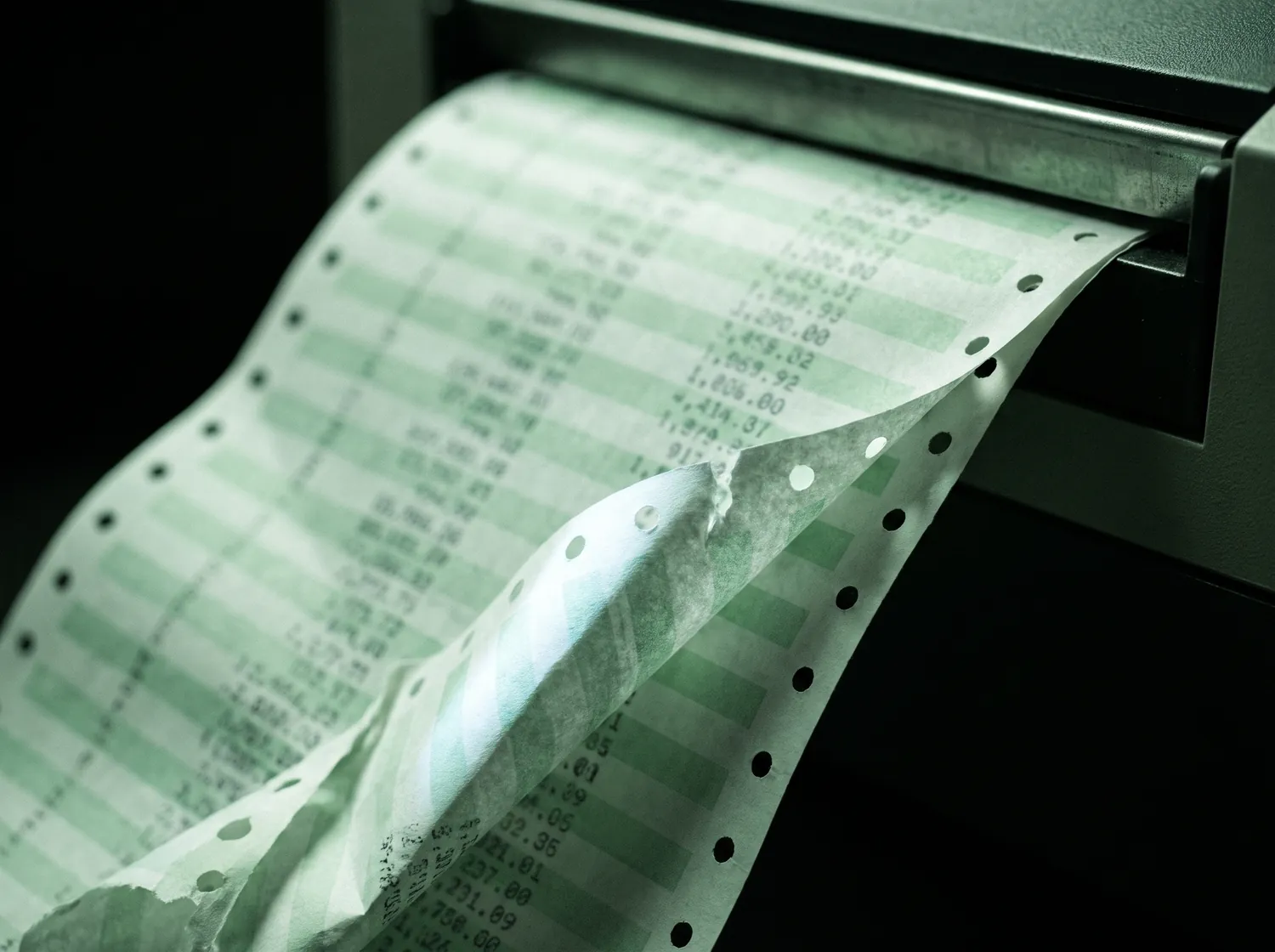 Continuous-feed accounting paper spilling from a line printer