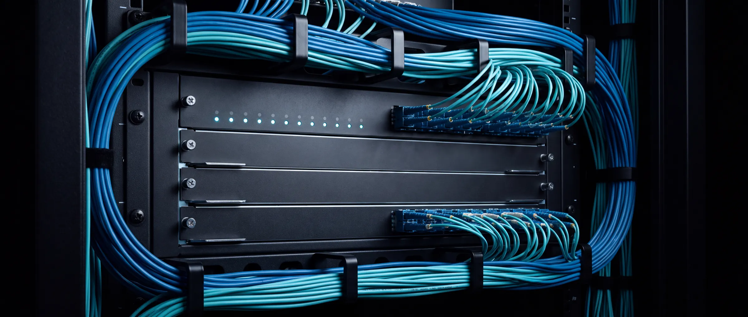 A core network switch chassis in a dark rack, fibre uplinks entering ordered cable management